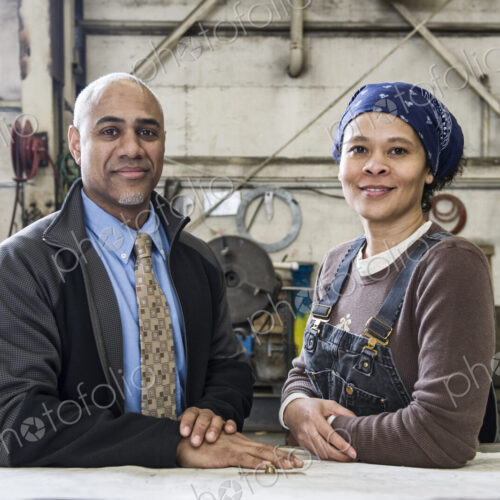 Black man owner of a sheet metal factoy and a black woman factory worker going over…