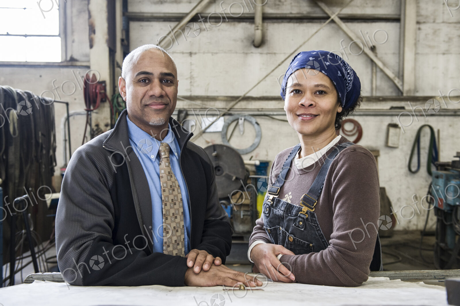 Black man owner of a sheet metal factoy and a black woman factory worker going over…