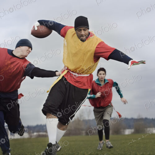 Black man running with the football and being chased by opponents in a non-contact… Black man running with the football and being chased by opponents in a non-contact…