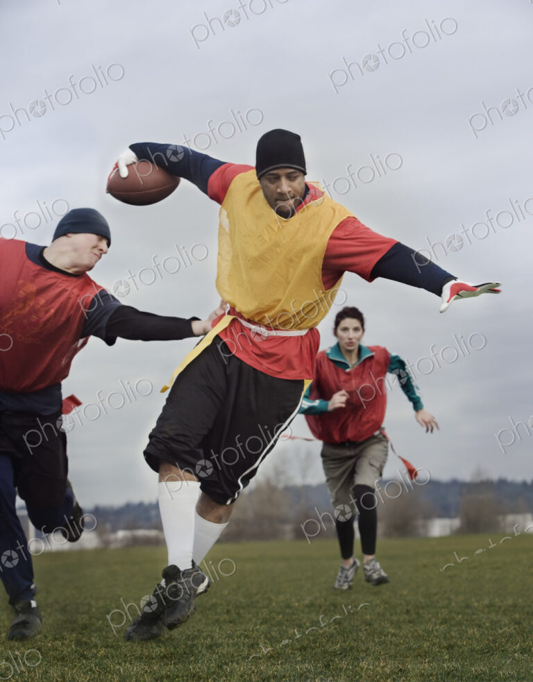 Black man running with the football and being chased by opponents in a non-contact…