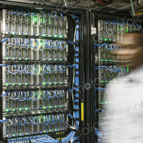 Black man technician doing diagnostic tests on computer servers in server farm. Black man technician doing diagnostic tests on computer servers in server farm.