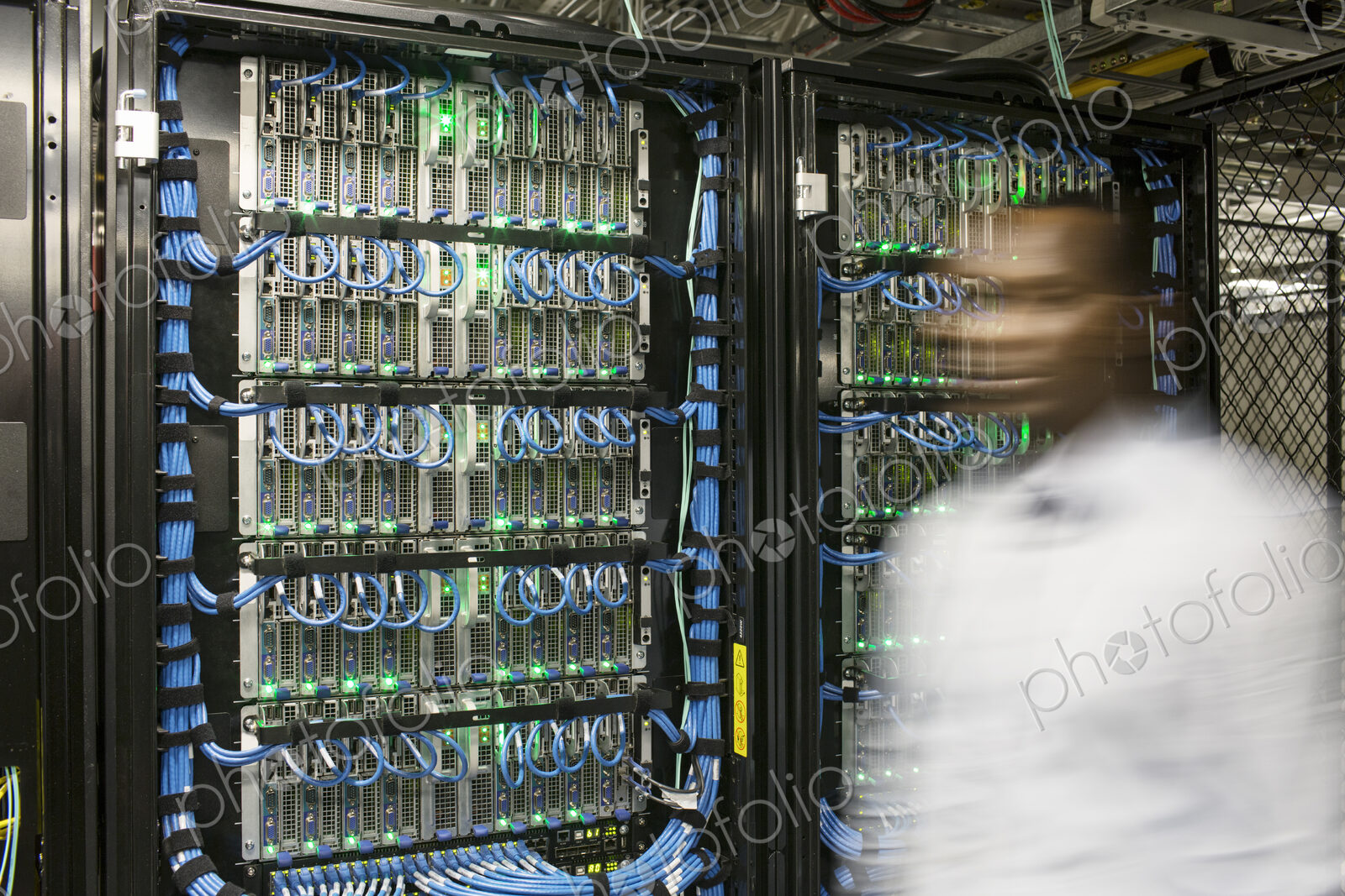 Black man technician doing diagnostic tests on computer servers in server farm.