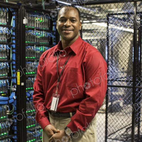 Black man technician in a computer server farm. Black man technician in a computer server farm.