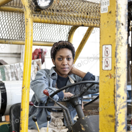 Black woman factory worker and a fork lift in a sheet metal factory. Black woman factory worker and a fork lift in a sheet metal factory.