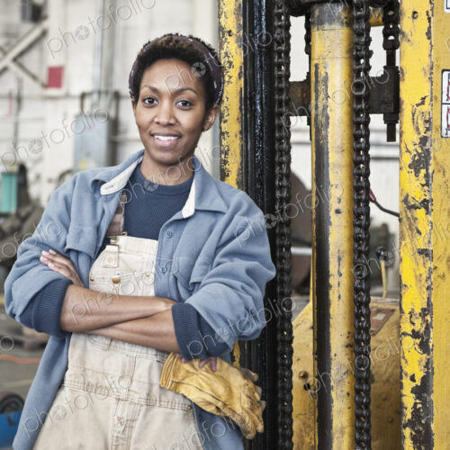 Black woman factory worker and a fork lift in a sheet metal factory. Black woman factory worker and a fork lift in a sheet metal factory.