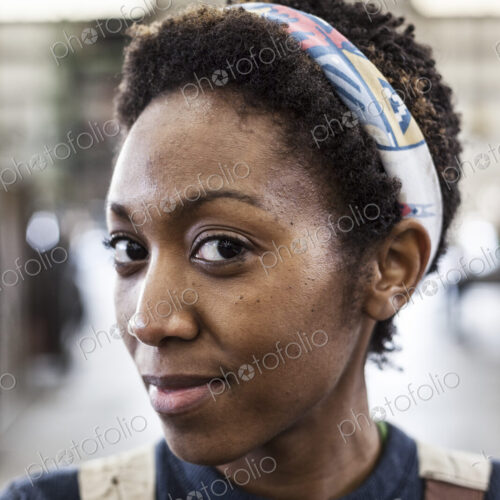 Black woman factory worker wearing coveralls in a large sheet metal factory. Black woman factory worker wearing coveralls in a large sheet metal factory.
