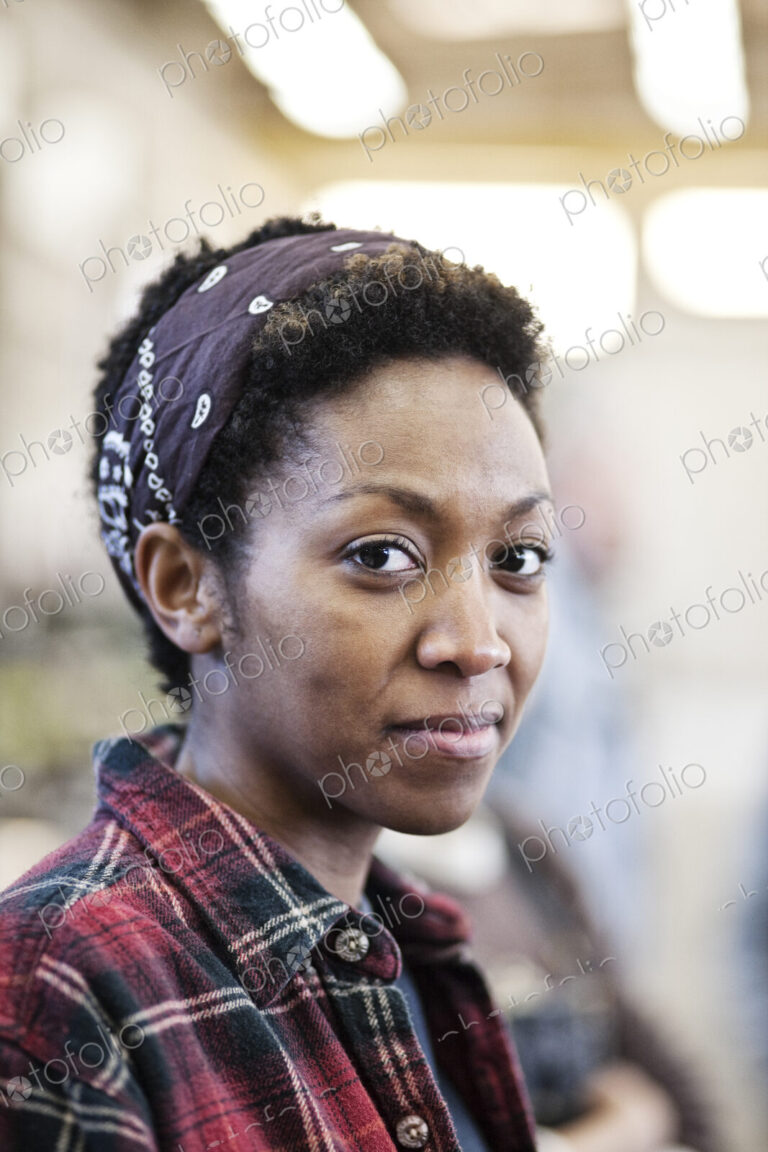 Black woman wearing a bandana in a factrory.