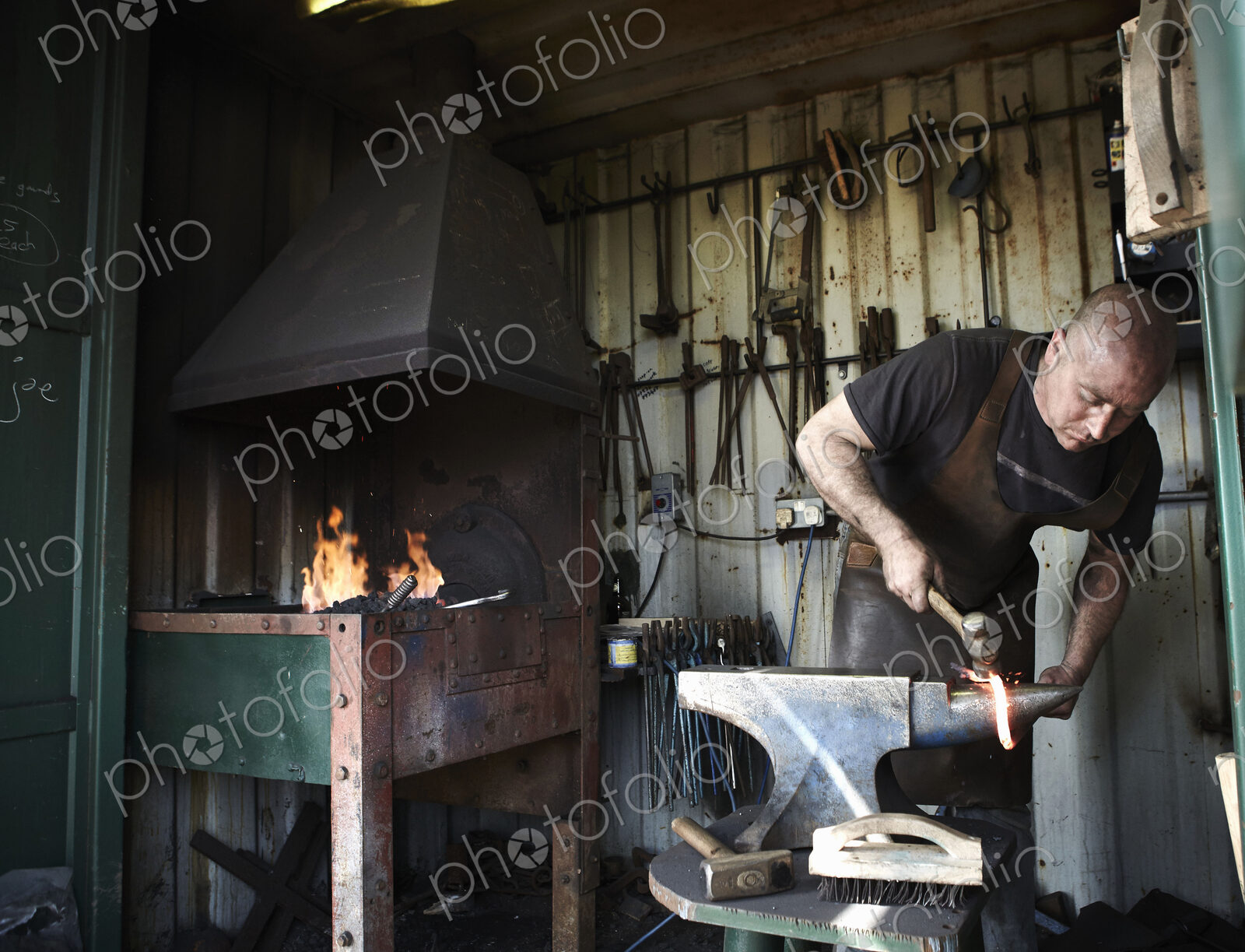 Blacksmith shaping a hot piece of iron on an anvil