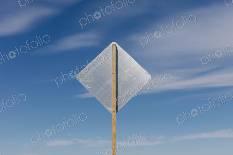 Blank side of a road sign, blue sky in background