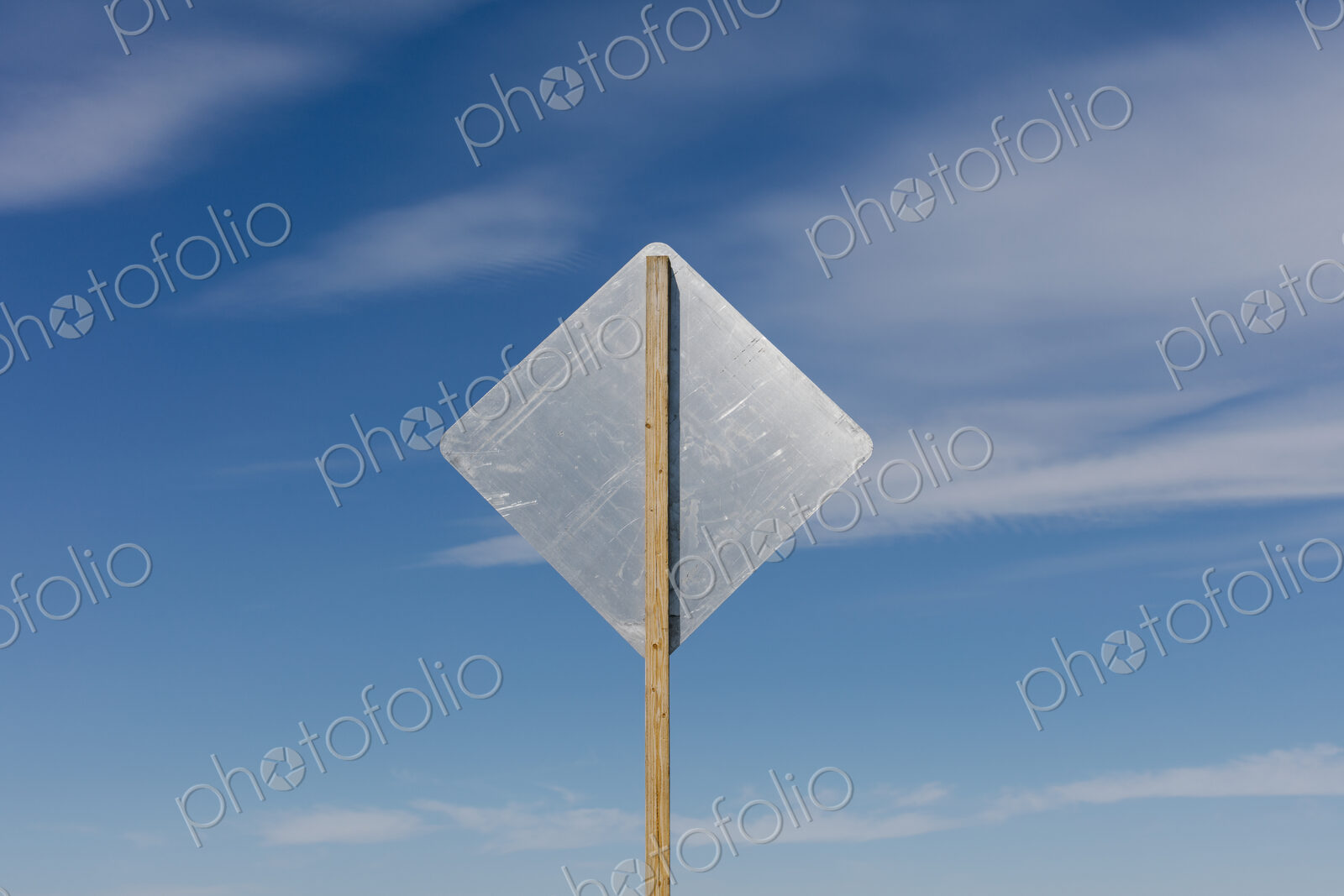 Blank side of a road sign, blue sky in background