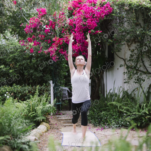 Blond woman doing yoga in a garden. Blond woman doing yoga in a garden.