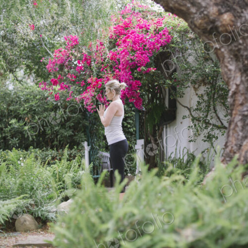 Blond woman doing yoga in a garden. Blond woman doing yoga in a garden.