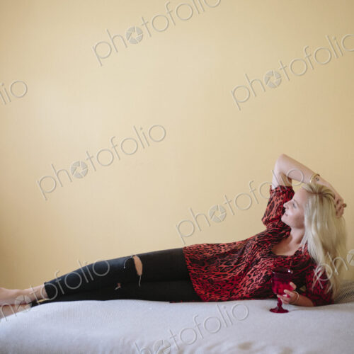 Blond woman reclining on a bed.