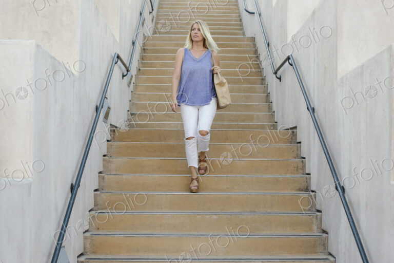 Blond woman walking down a staircase.