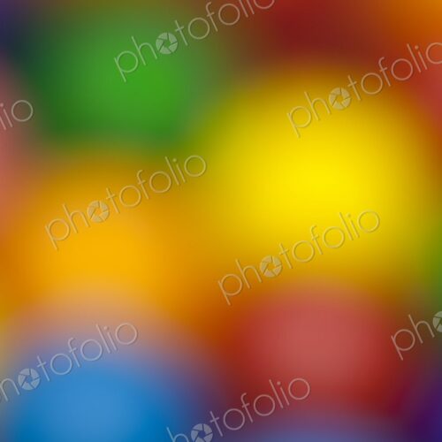 Blurred close-up of multicolored gumballs creating a soft, vibrant background. Ideal…