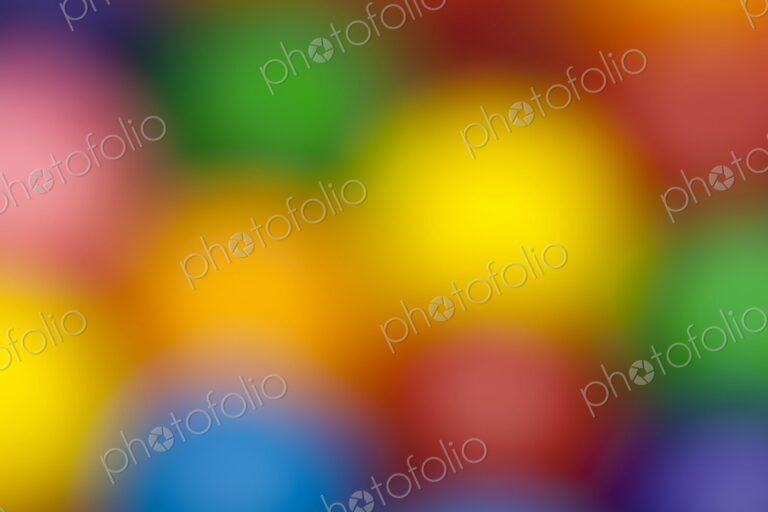 Blurred close-up of multicolored gumballs creating a soft, vibrant background. Ideal…