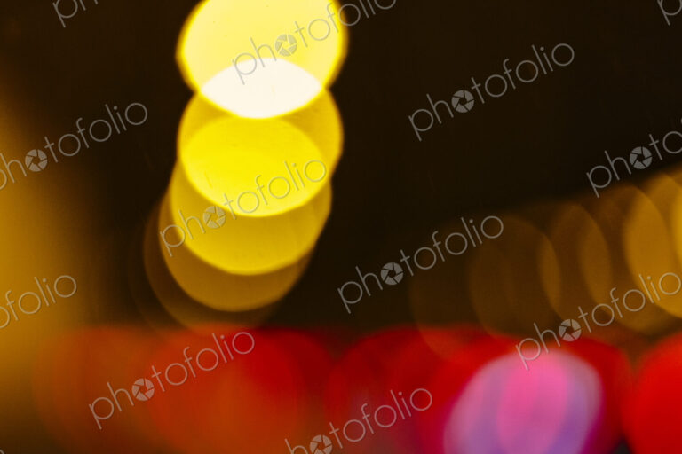 Blurred headlights and tail lights at night, abstract patterns.