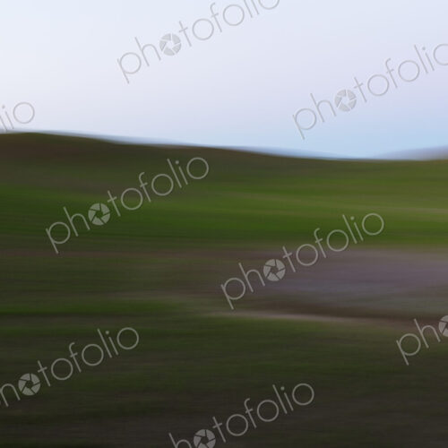 Blurred motion abstract of rolling wheat fields at dusk, layers of natural colour