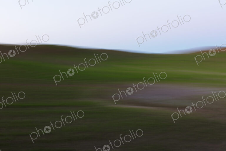 Blurred motion abstract of rolling wheat fields at dusk, layers of natural colour