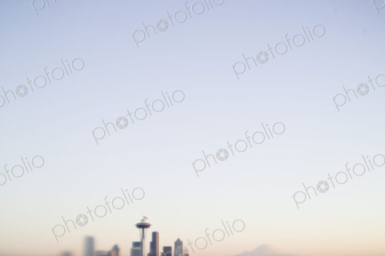 Blurred urban skyline with blue sky above.