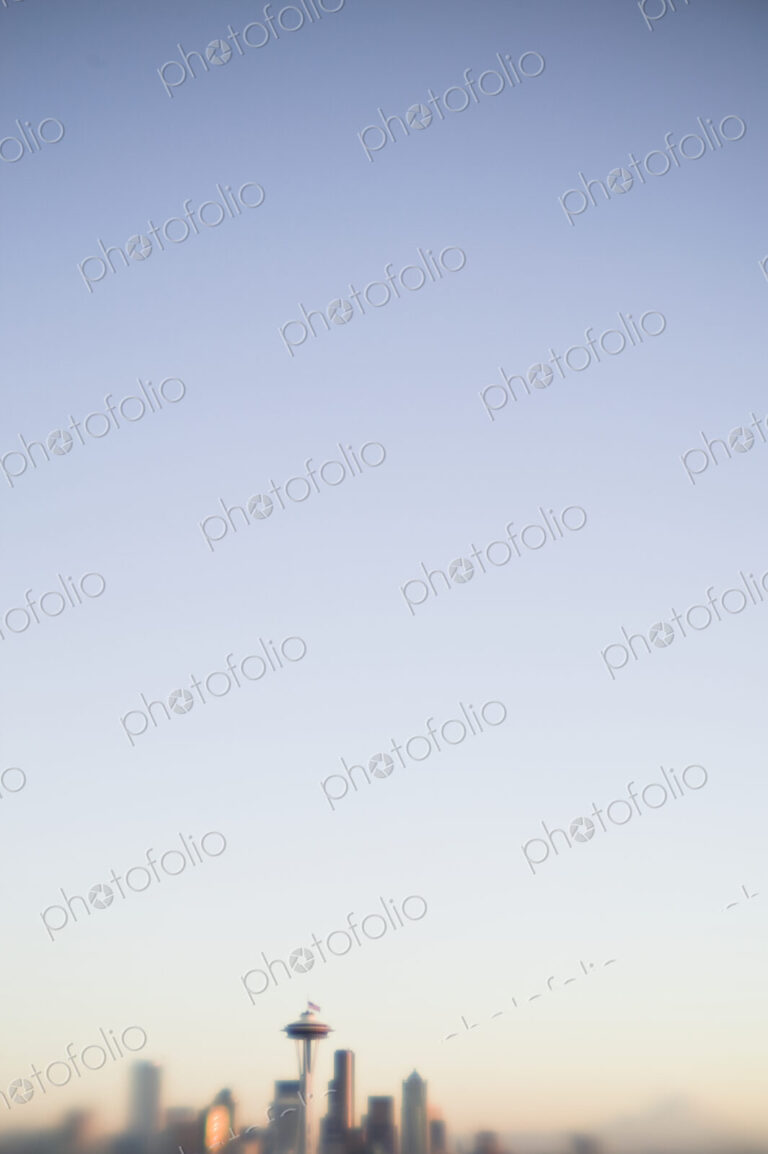 Blurred urban skyline with blue sky above.