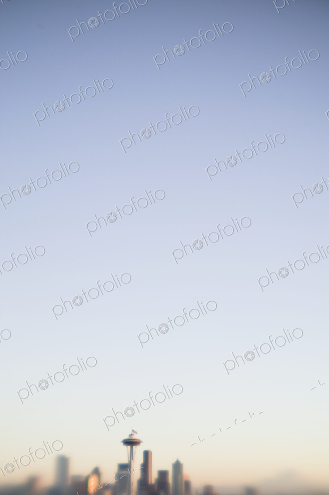 Blurred urban skyline with blue sky above.