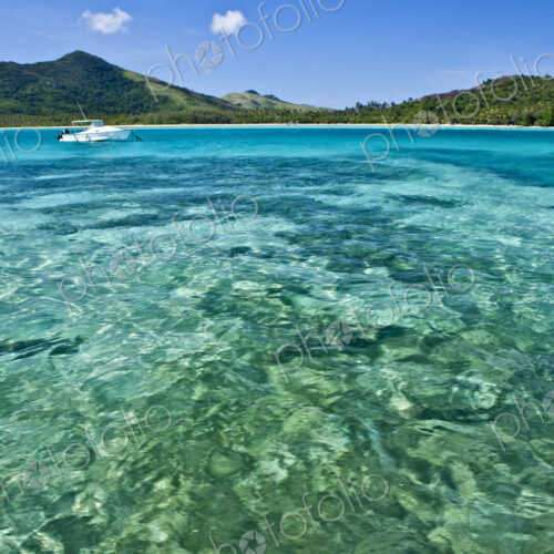Boat Anchored Offshore Of A Tropical Island Boat Anchored Offshore Of A Tropical Island