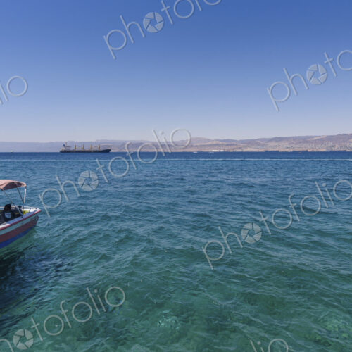 Boat moored in the Red Sea, Jordan, with coastline in the distance. Boat moored in the Red Sea, Jordan, with coastline in the distance.