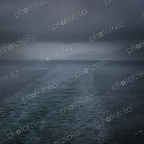 Boat wake behind San Juan Islands ferry on a stormy day with black clouds. Boat wake behind San Juan Islands ferry on a stormy day with black clouds.