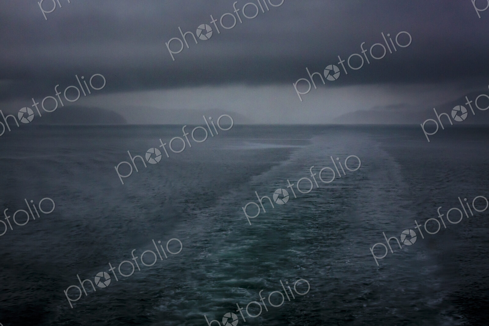 Boat wake behind the San Juan Islands ferry, low cloud and a stormy outlook.