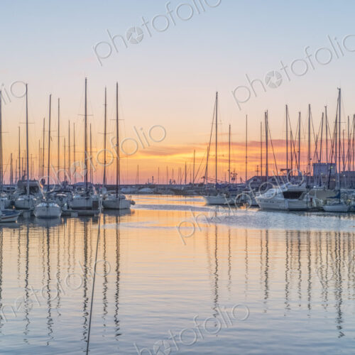 Boats moored in the harbour marina in Palermo at sunrise.