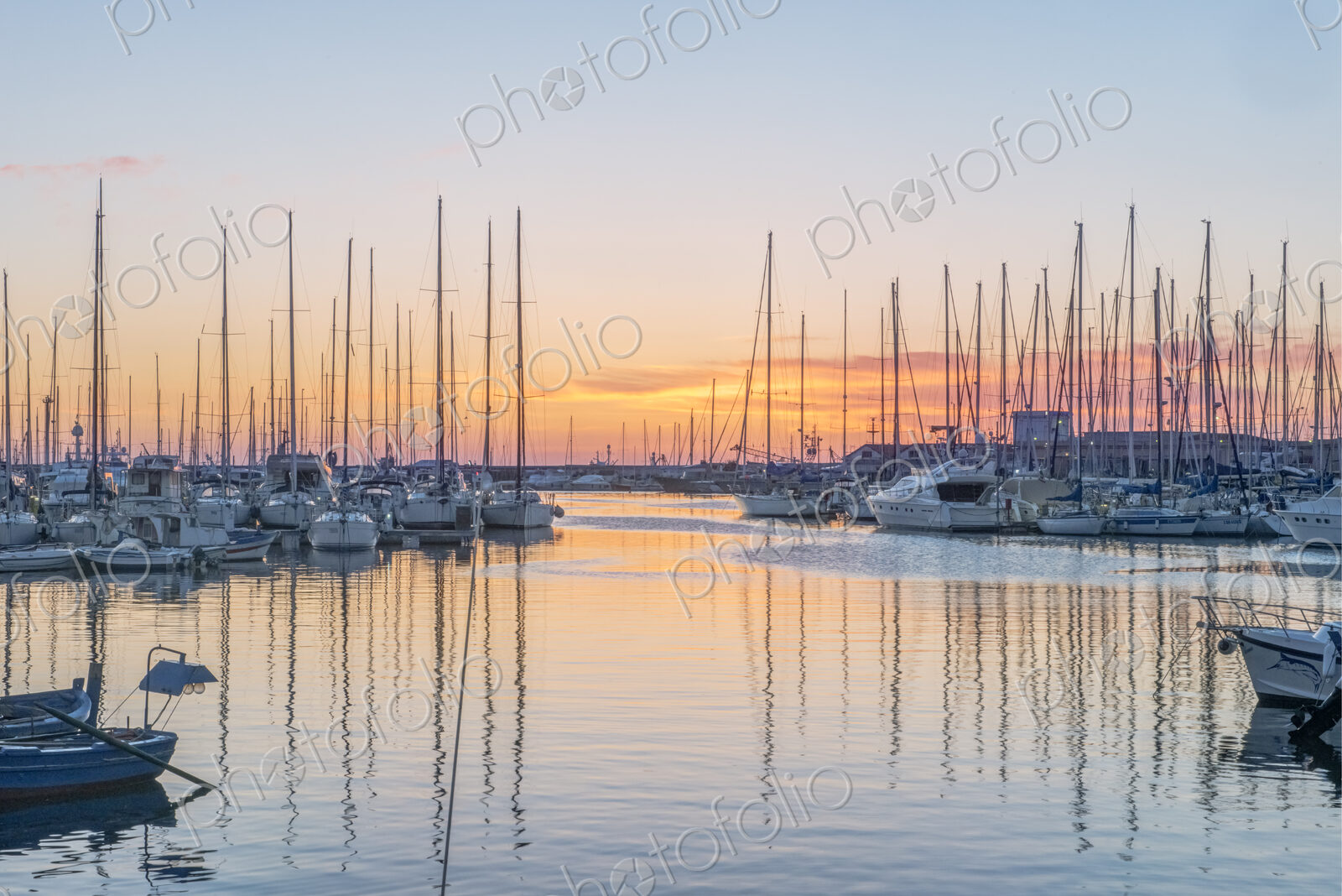 Boats moored in the harbour marina in Palermo at sunrise.