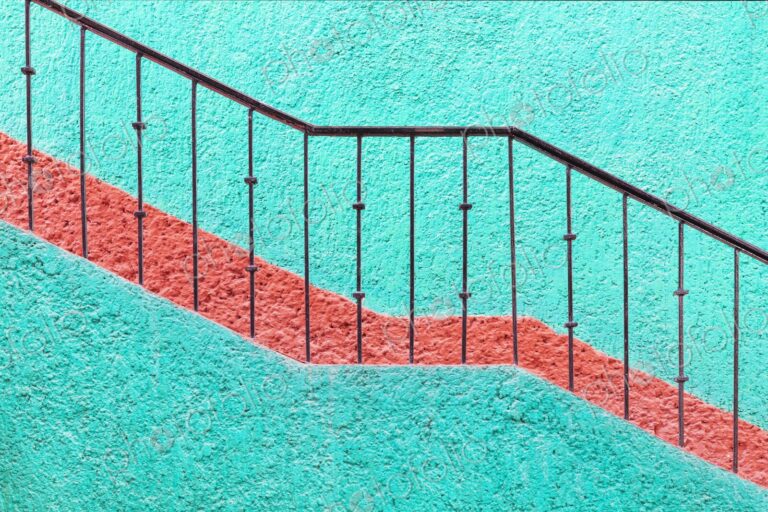 Bold turquoise wall with red stripe and iron railing in Cancun, Mexico. A vibrant,…