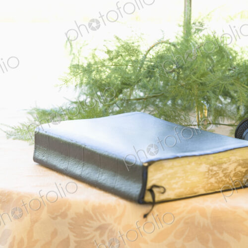 Book and microphone on table with floral arrangement. Book and microphone on table with floral arrangement.