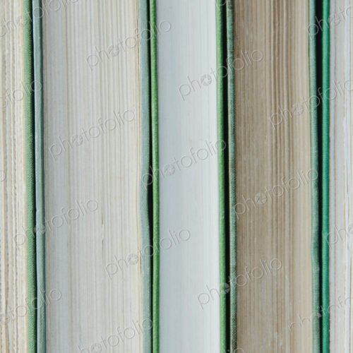 Books in a row, with green hard covers, and white and beige paper edges. Books in a row, with green hard covers, and white and beige paper edges.