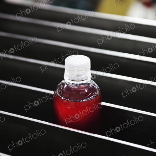 Bottle in processing machinery in packaging plant. Bottle in processing machinery in packaging plant.