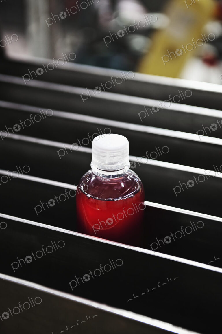 Bottle in processing machinery in packaging plant.