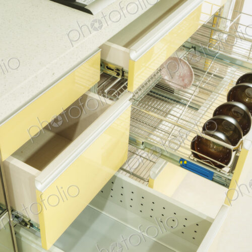 Bowls and dish in a kitchen cupboard with stainless steel racks.