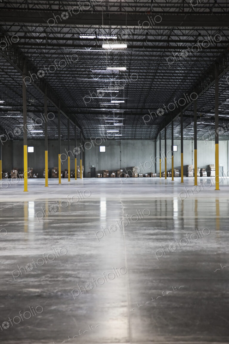 Boxes along wall in distance in warehouse