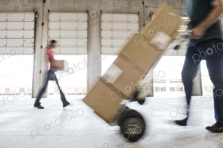 Boxes being moved into a new empty warehouse.