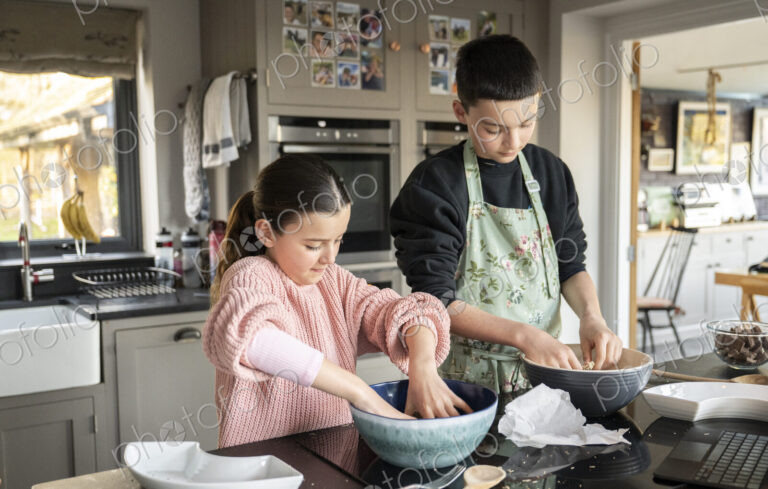 Boy and girl baking together in kitchen.