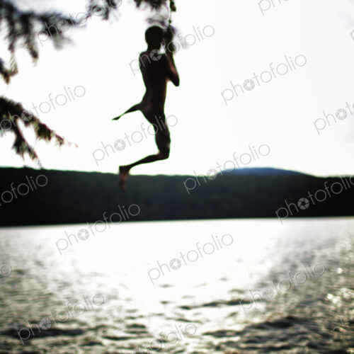 Boy jumping off rope swing Boy jumping off rope swing