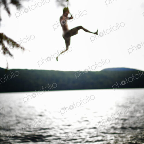 Boy jumping off rope swing Boy jumping off rope swing