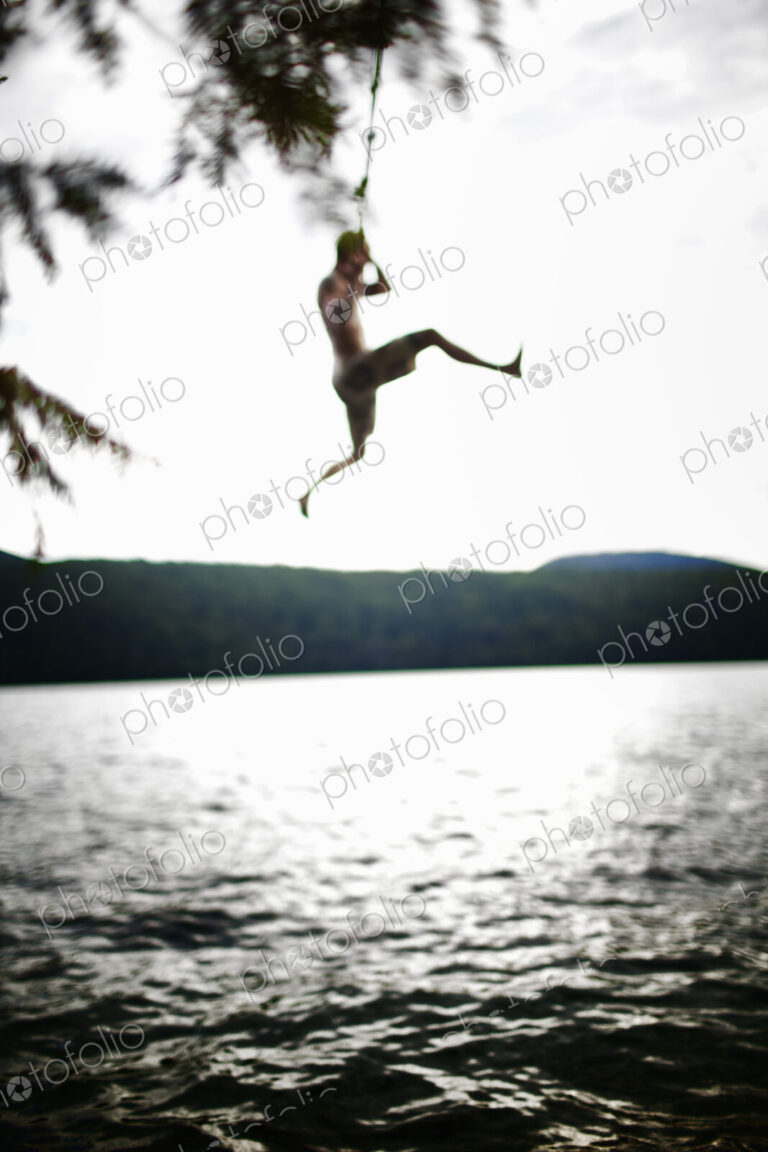 Boy jumping off rope swing