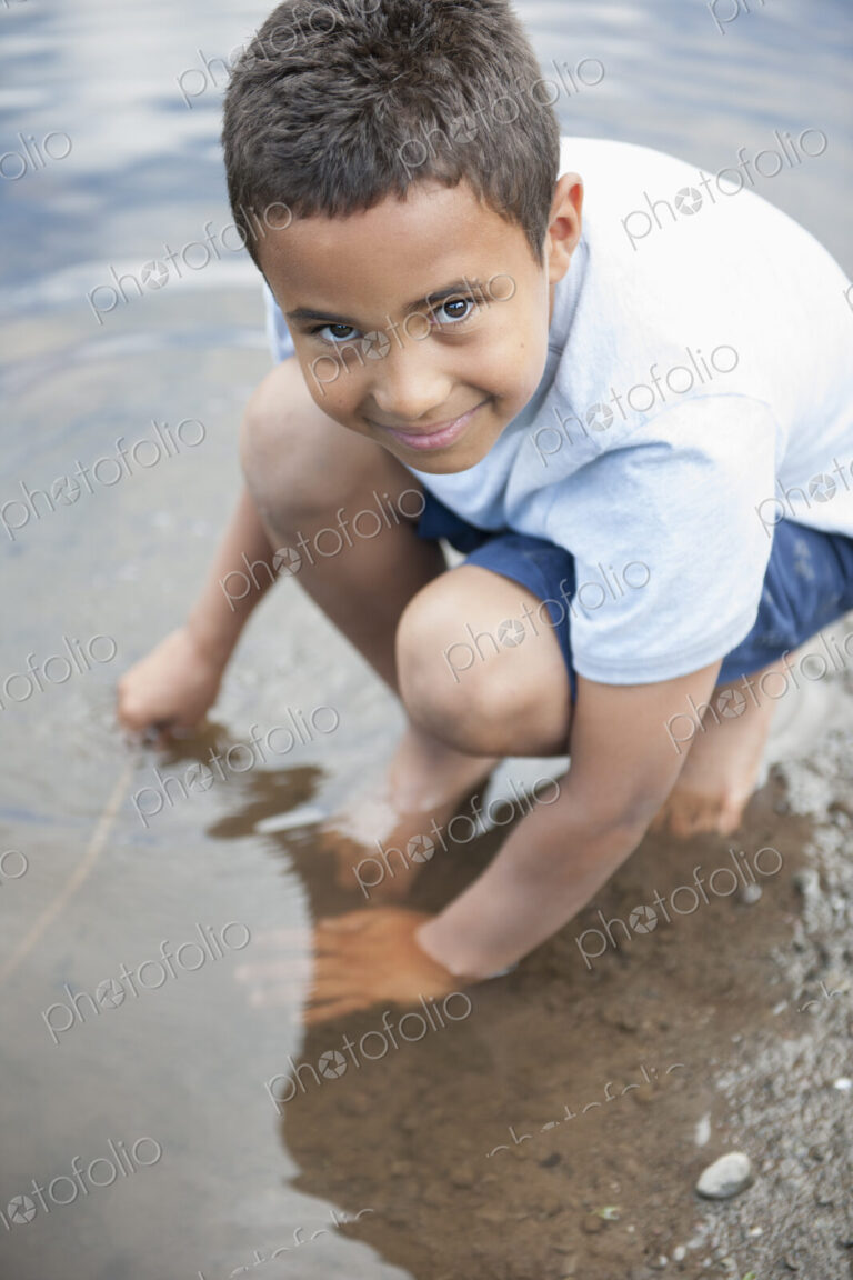 Boy playing by a lake.