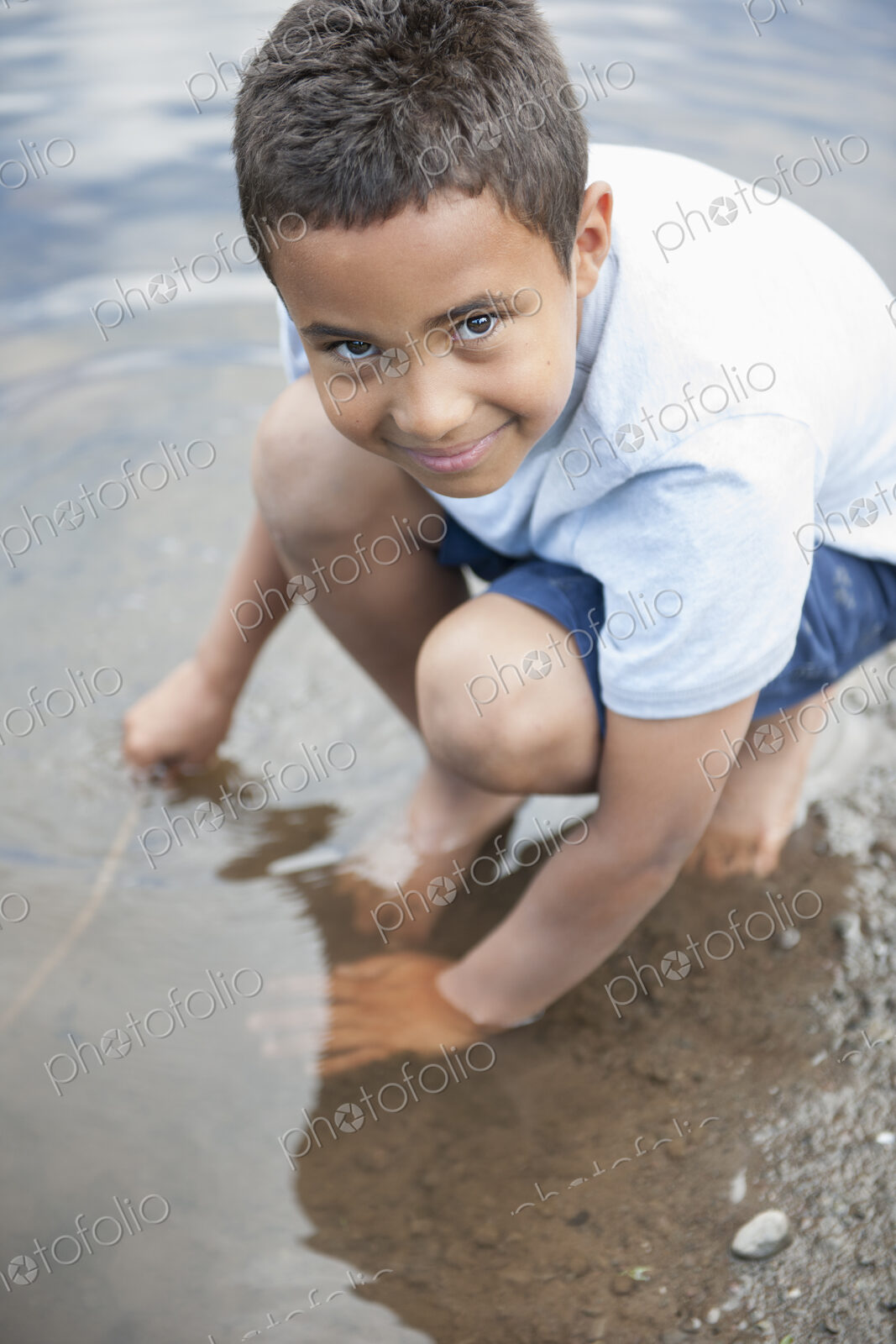 Boy playing by a lake.