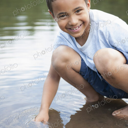 Boy playing by a lake. Boy playing by a lake.