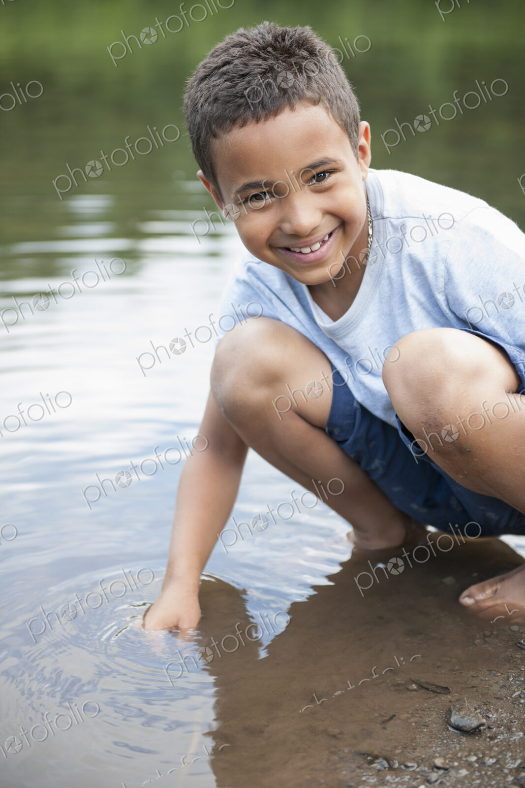 Boy playing by a lake.