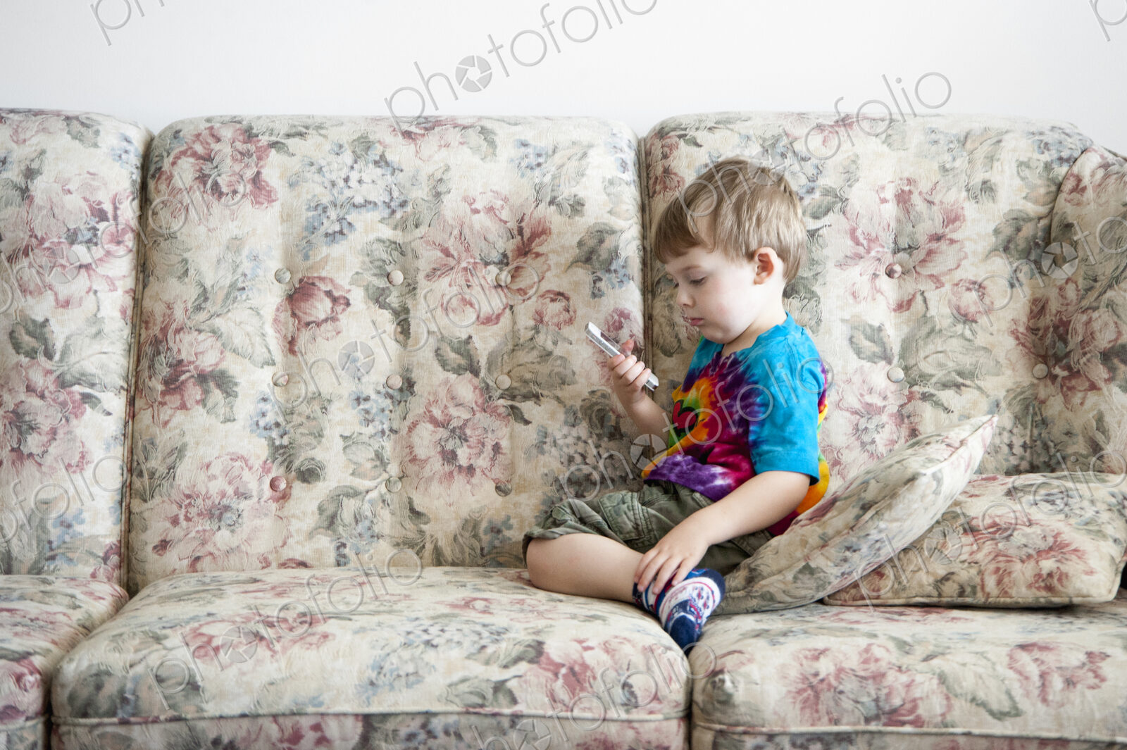 Boy playing with cell phone on sofa