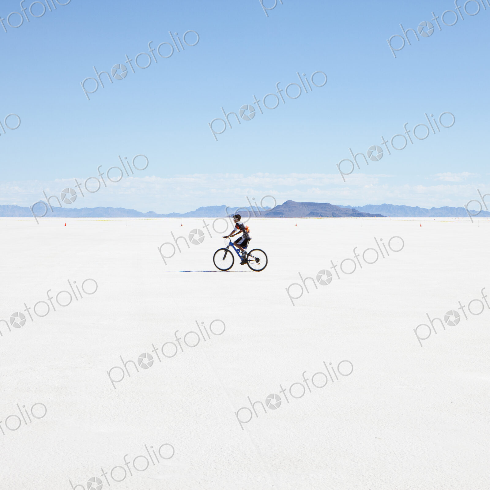 Boy riding bike on salt flats, during Speed Week